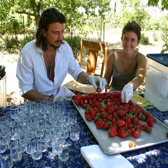 two people preparing strawberries for an event