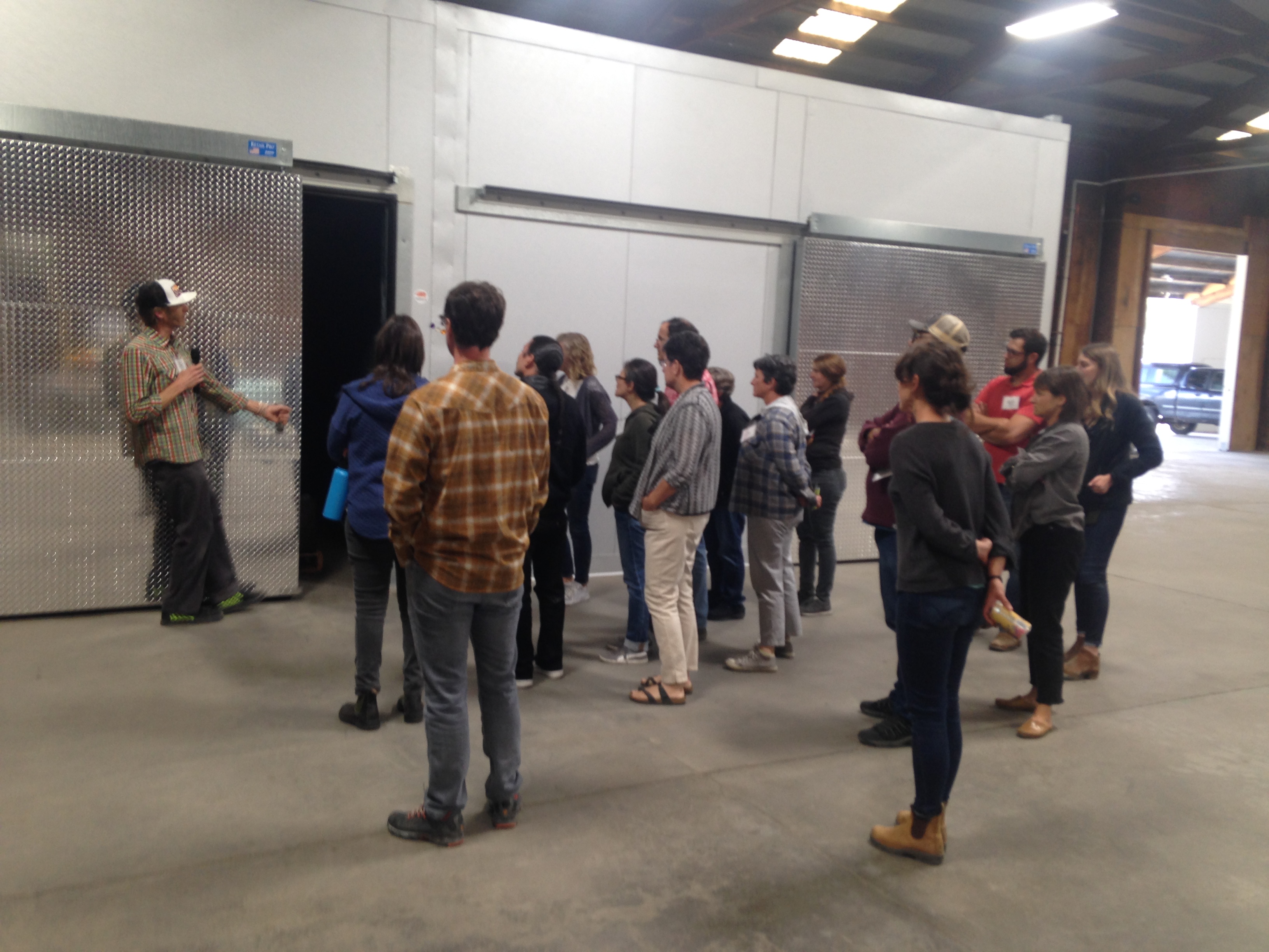 A man gives a tour of a food hub facility to a small group
