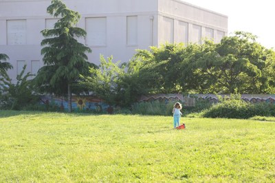 girl playing in field in a city