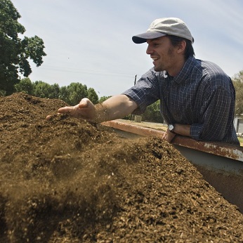 Man running hands through pile of soil