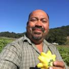 Close up of smiling man holding a summer squash
